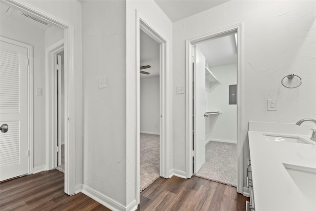 bathroom featuring visible vents, a sink, baseboards, and wood finished floors