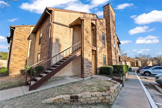 2109 Horizon Trl Unit 4014, Arlington, TX 76011 - view of front of property with uncovered parking, a chimney, stairs, brick siding, and fence