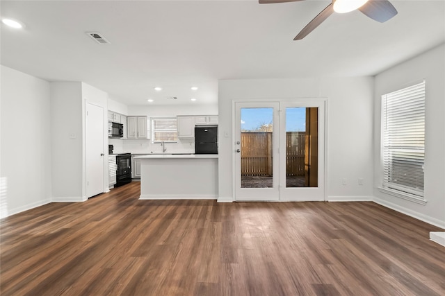 unfurnished living room featuring baseboards, visible vents, dark wood finished floors, a ceiling fan, and recessed lighting