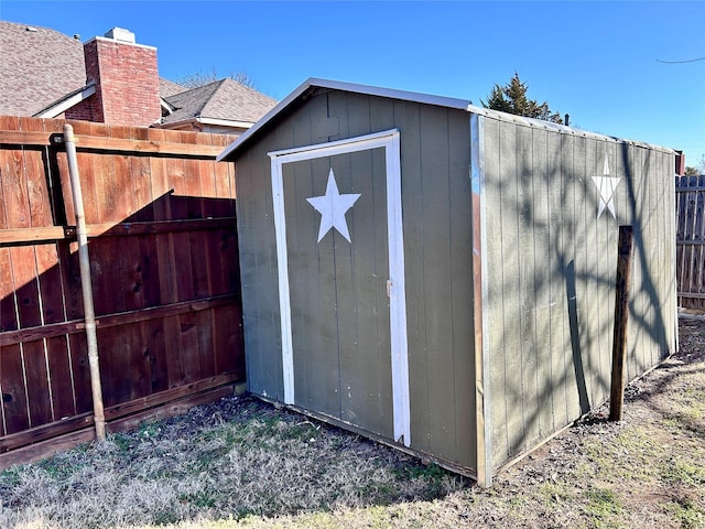 view of shed featuring fence