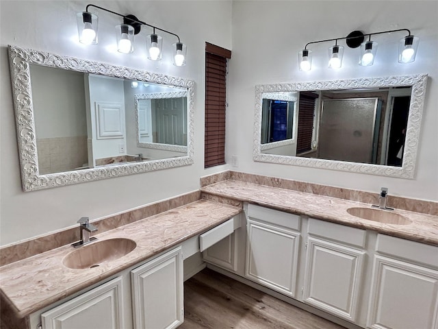 full bathroom featuring wood finished floors, a shower stall, and vanity