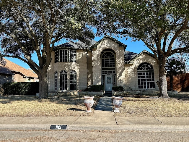 view of front of house with fence and brick siding