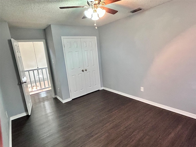 unfurnished bedroom with dark wood-style flooring, visible vents, and baseboards