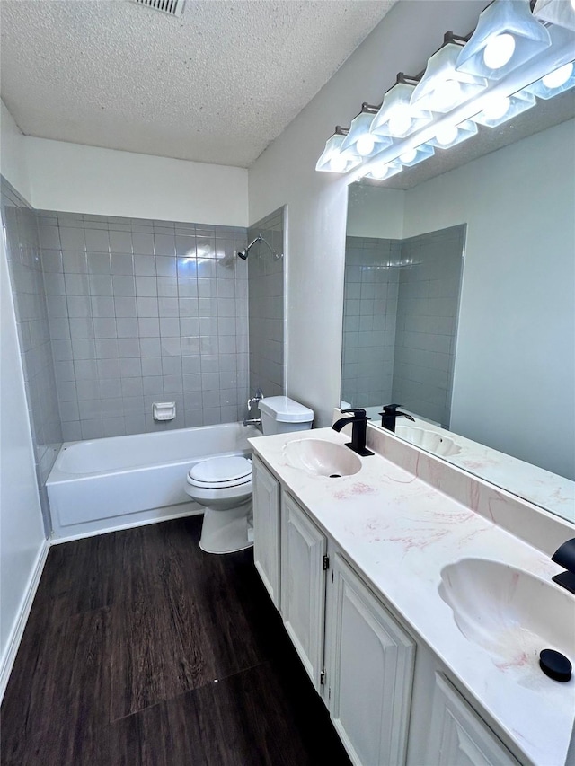 full bathroom featuring a textured ceiling, wood finished floors, and a sink