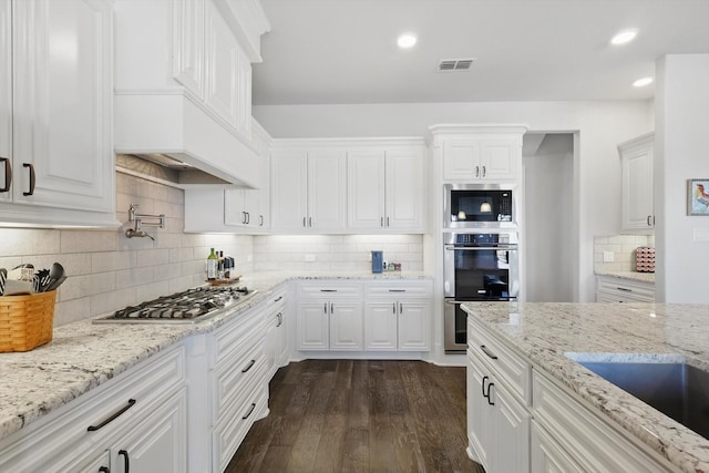 kitchen featuring white cabinetry, appliances with stainless steel finishes, visible vents, and dark wood finished floors