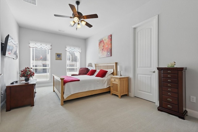 bedroom with light colored carpet, ceiling fan, and visible vents