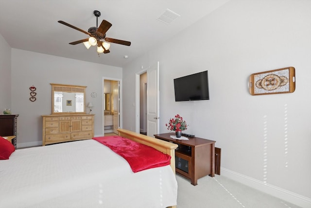 carpeted bedroom featuring a ceiling fan, connected bathroom, visible vents, and baseboards