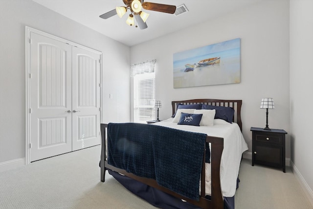 carpeted bedroom with ceiling fan, a closet, visible vents, and baseboards