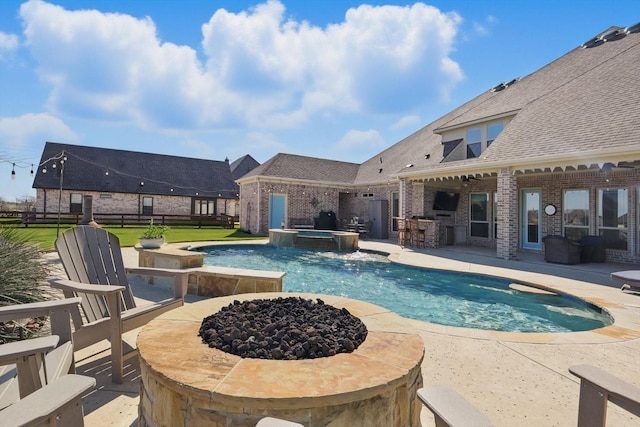 view of pool featuring an outdoor fire pit, a patio, outdoor dry bar, fence, and a pool with connected hot tub