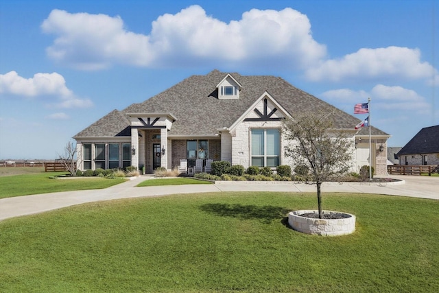 view of front of house featuring brick siding, roof with shingles, and a front yard