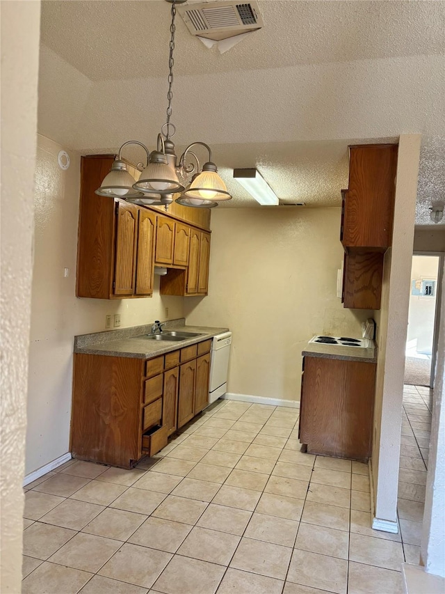 kitchen with brown cabinets, visible vents, light tile patterned flooring, a sink, and dishwasher