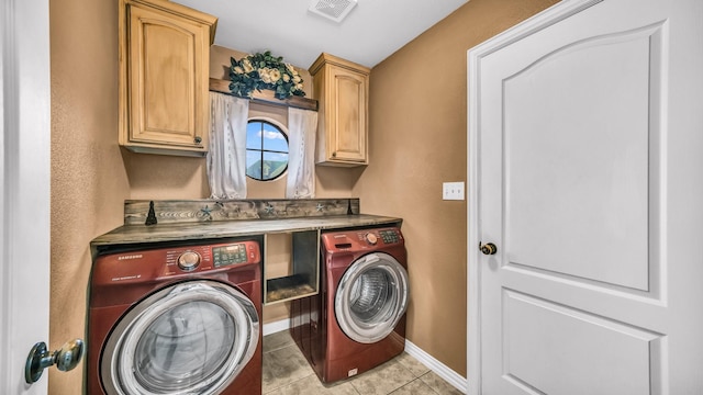 washroom featuring light tile patterned floors, visible vents, baseboards, cabinet space, and washing machine and clothes dryer