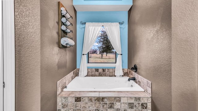 bathroom with a bath and a textured wall