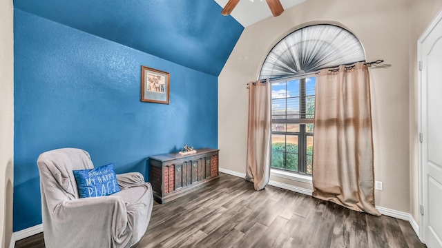 living area featuring lofted ceiling, ceiling fan, baseboards, and wood finished floors