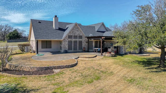 rear view of property with a yard, a chimney, a patio area, and cooling unit