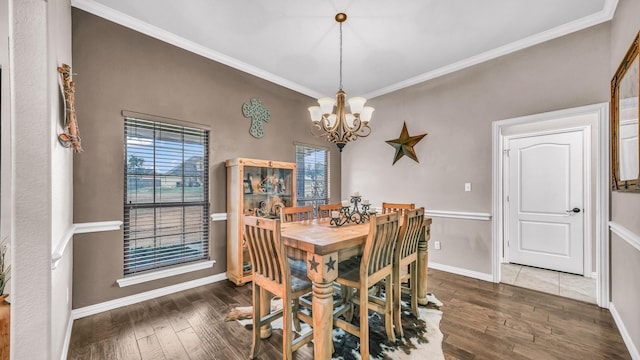 dining area with ornamental molding, baseboards, hardwood / wood-style floors, and an inviting chandelier