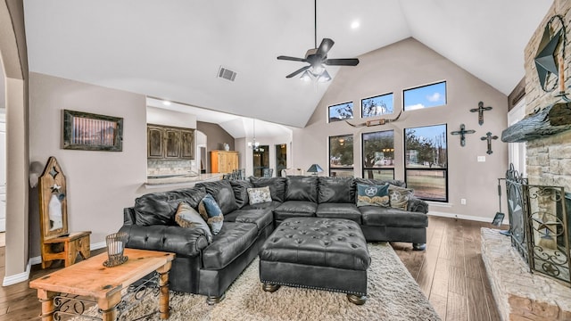 living room with high vaulted ceiling, hardwood / wood-style flooring, a fireplace, and visible vents