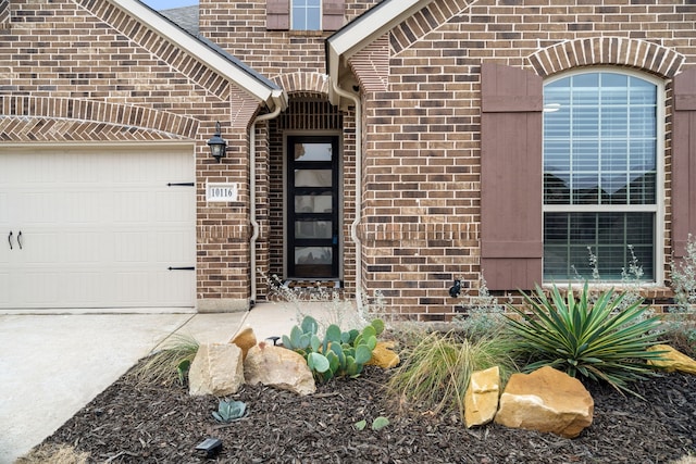 doorway to property with brick siding and an attached garage