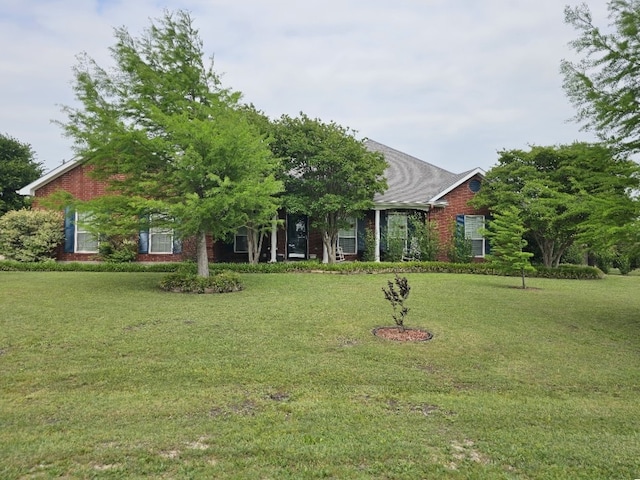 view of front of house featuring a front yard and brick siding