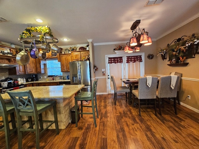 interior space with dark wood-style flooring, baseboards, visible vents, a notable chandelier, and crown molding