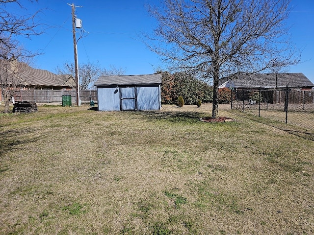 view of yard featuring a shed, an outdoor structure, and fence