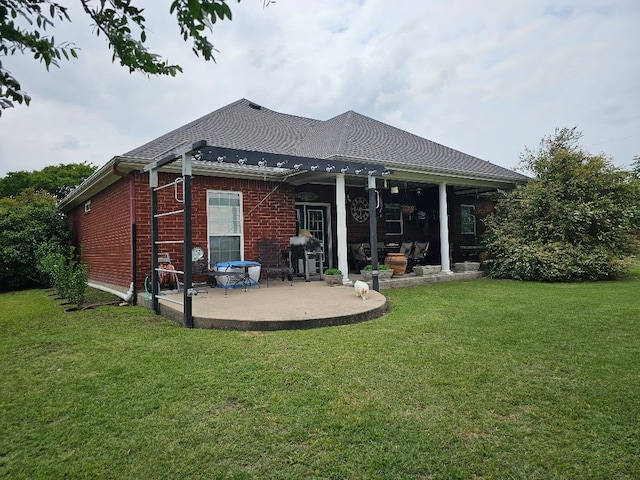 back of property with a patio, brick siding, and a yard