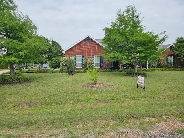 view of front facade with a front lawn and brick siding