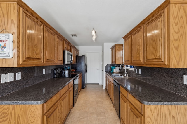 kitchen with brown cabinetry, a sink, backsplash, and black appliances