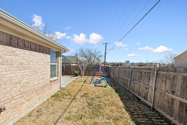 view of yard featuring a fenced backyard and a playground