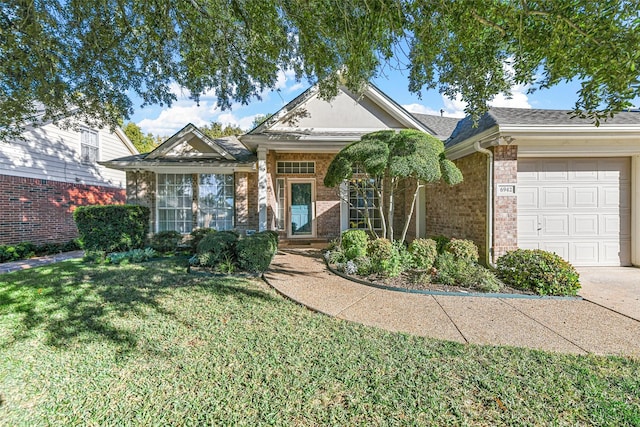 view of front of property with an attached garage, brick siding, and a front yard