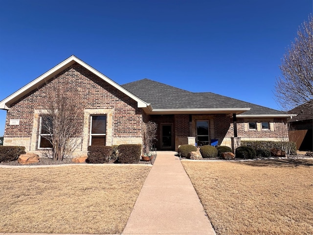 single story home with a shingled roof and brick siding