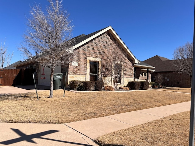 view of front of property featuring brick siding, concrete driveway, an attached garage, fence, and stone siding