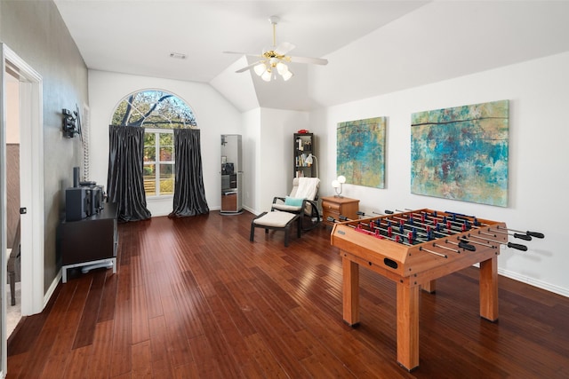 recreation room with lofted ceiling, wood-type flooring, visible vents, a ceiling fan, and baseboards