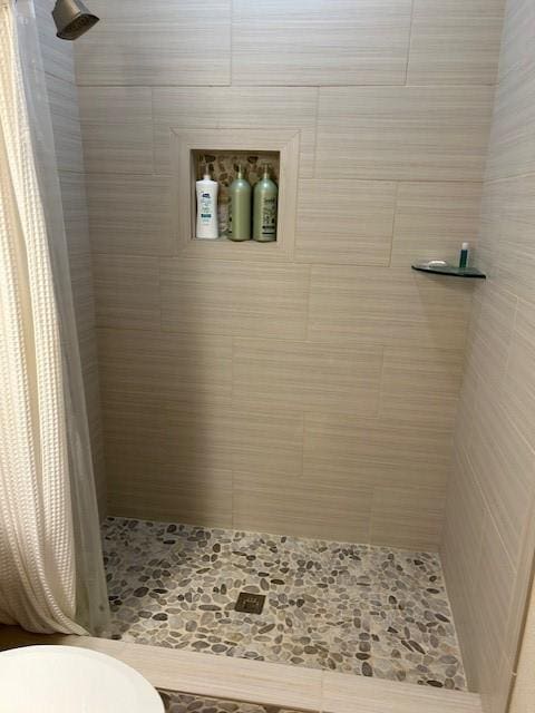 bathroom featuring a stall shower and toilet