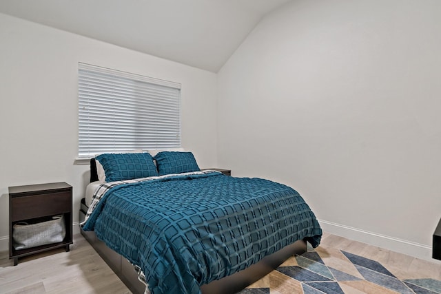 bedroom featuring vaulted ceiling, baseboards, and wood finished floors