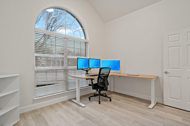 office area featuring baseboards, vaulted ceiling, and wood finished floors