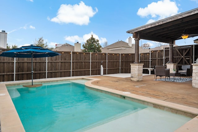 view of pool with ceiling fan, fence, a fenced in pool, and a patio