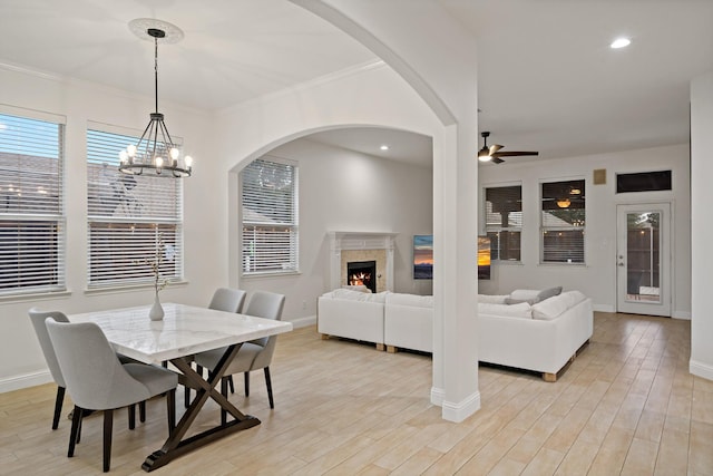 dining space with light wood-type flooring, recessed lighting, baseboards, and a premium fireplace