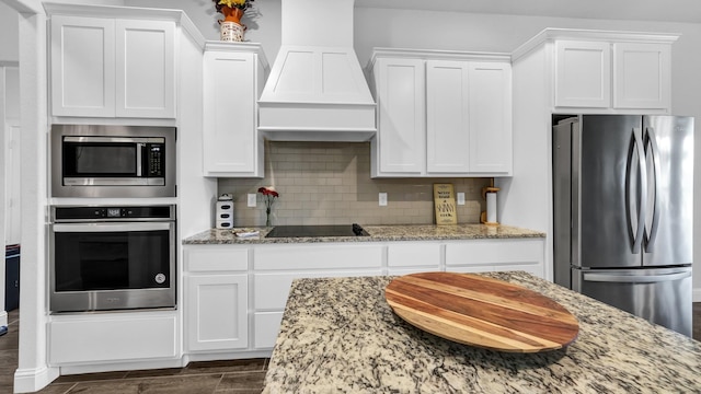 kitchen featuring stainless steel appliances, tasteful backsplash, custom exhaust hood, and white cabinets