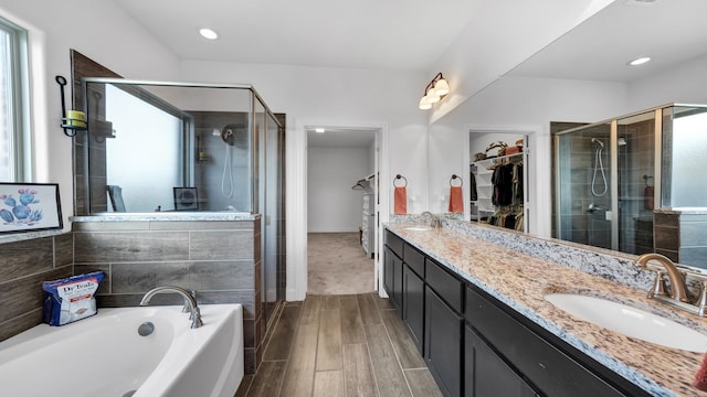 bathroom featuring a stall shower, a walk in closet, a sink, and wood tiled floor