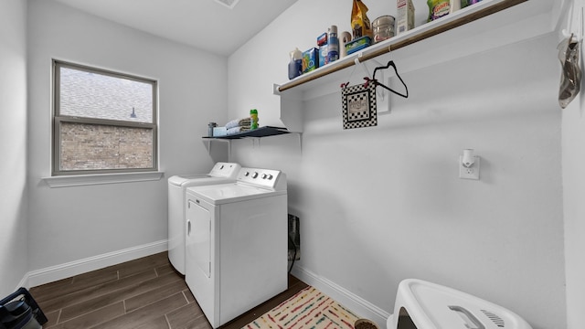 laundry room featuring laundry area, wood tiled floor, baseboards, and washer and clothes dryer