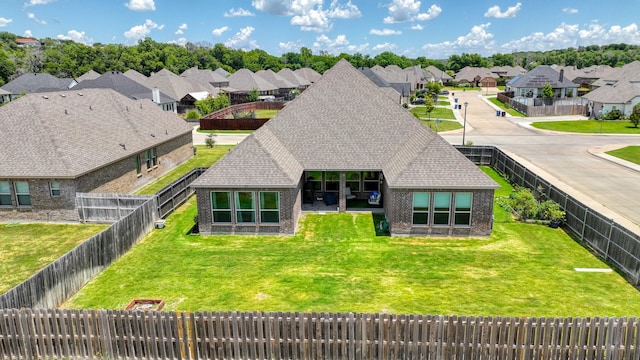 exterior space featuring brick siding, a fenced backyard, and roof with shingles