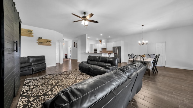 living area with recessed lighting, dark wood-style flooring, baseboards, and ceiling fan with notable chandelier