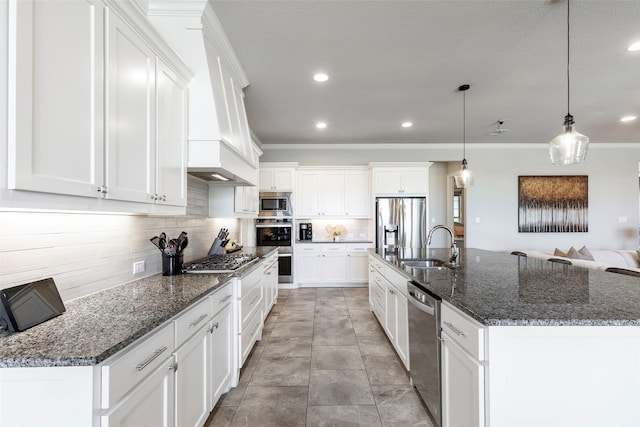 kitchen featuring a sink, white cabinets, appliances with stainless steel finishes, tasteful backsplash, and custom range hood