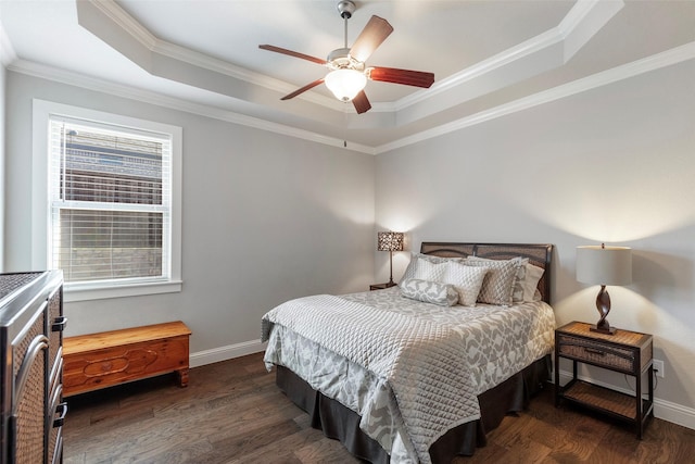 bedroom with wood finished floors, a raised ceiling, and baseboards