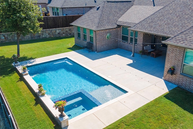 view of pool featuring a fenced backyard, a pool with connected hot tub, a lawn, and a patio