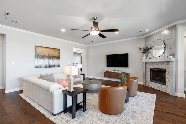 living room with wood finished floors, visible vents, baseboards, a ceiling fan, and crown molding