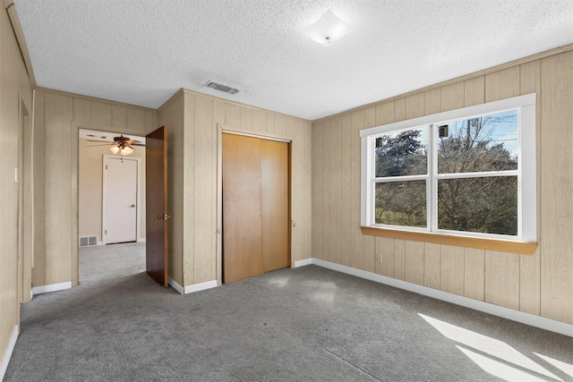 unfurnished bedroom with baseboards, a textured ceiling, visible vents, and a closet