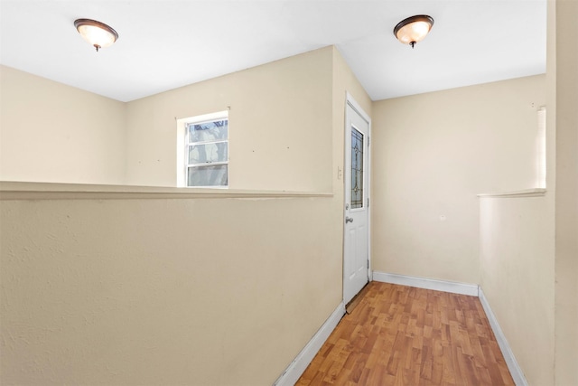 corridor featuring wood finished floors and baseboards