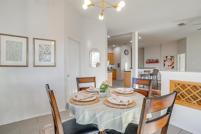 dining space with an inviting chandelier, light tile patterned flooring, baseboards, and visible vents